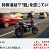 幹線道路を走る赤いモンキーと、追い抜いていく車の残像。「50cc、幹線道路で『壁』を感じていませんか？」というキャッチコピーが添えられたスライド